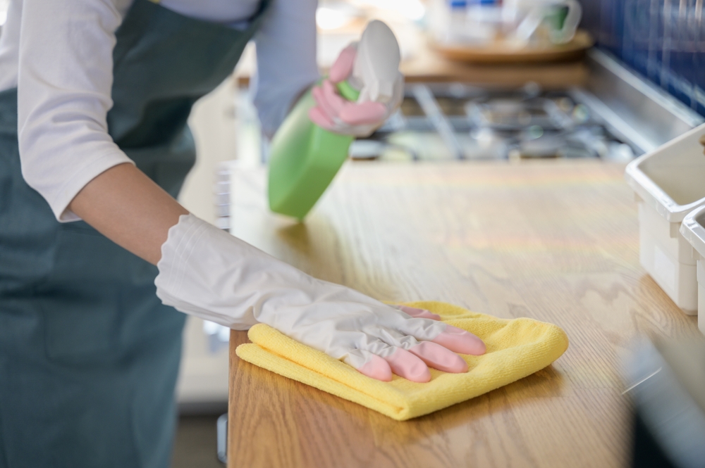 Close,Up,Hand,Of,Woman,Wearing,Rubber,Gloves,Cleaning,Wooden